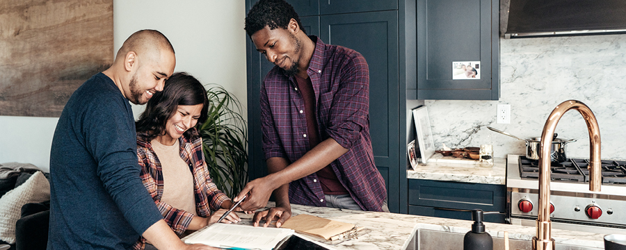 Couple looking at home renovation plans with salesperson